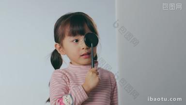 小女孩拿着遮眼板测视力